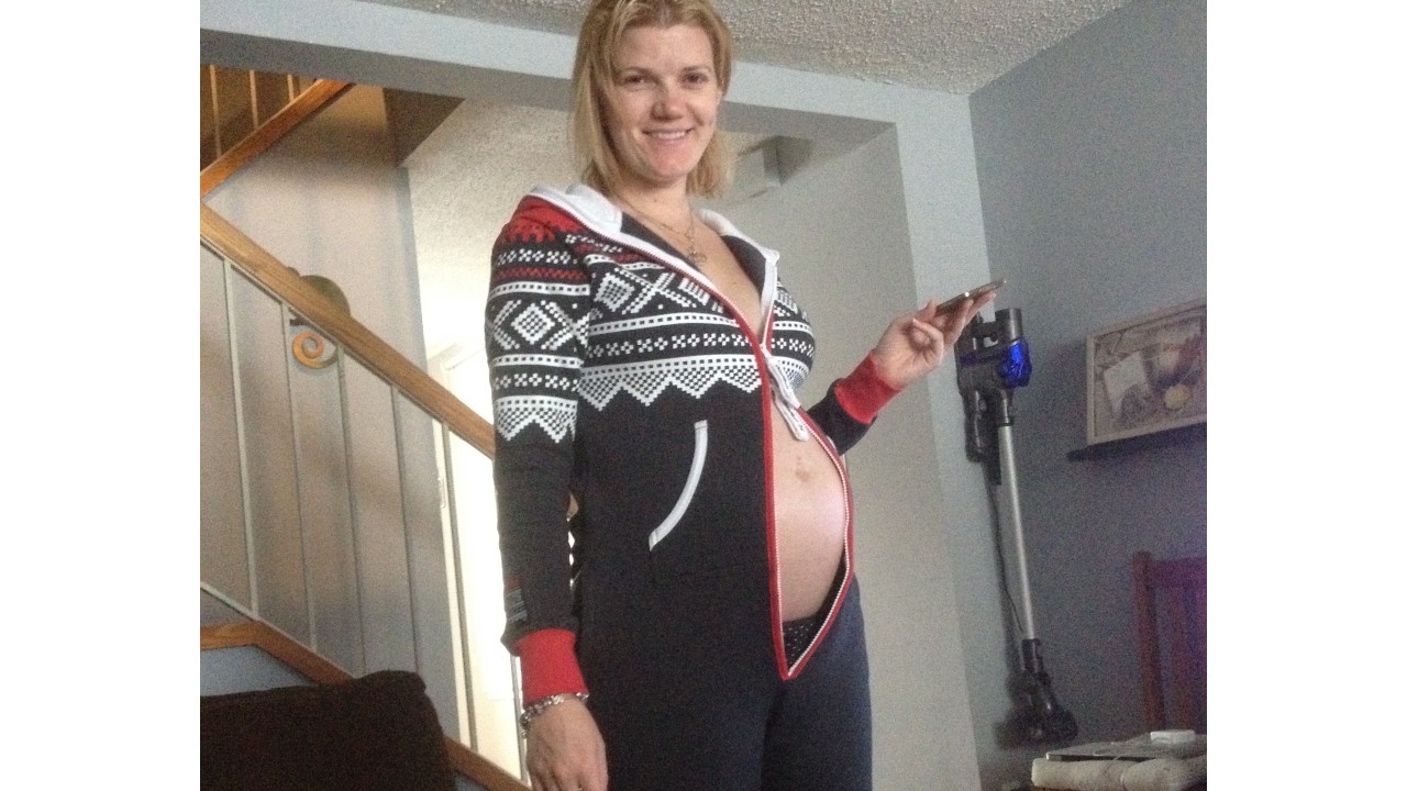 the writer wearing a onesie with pregnant belly poking out