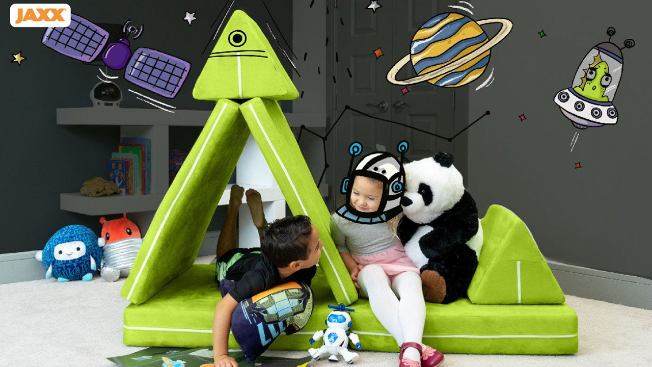 Photo of two kids playing on a modular play couch set up like a space ship