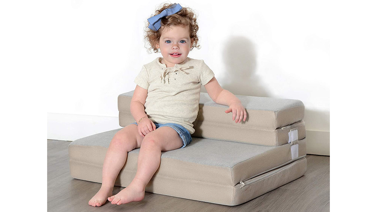 Photo of a toddler sitting on a foldable cushion couch