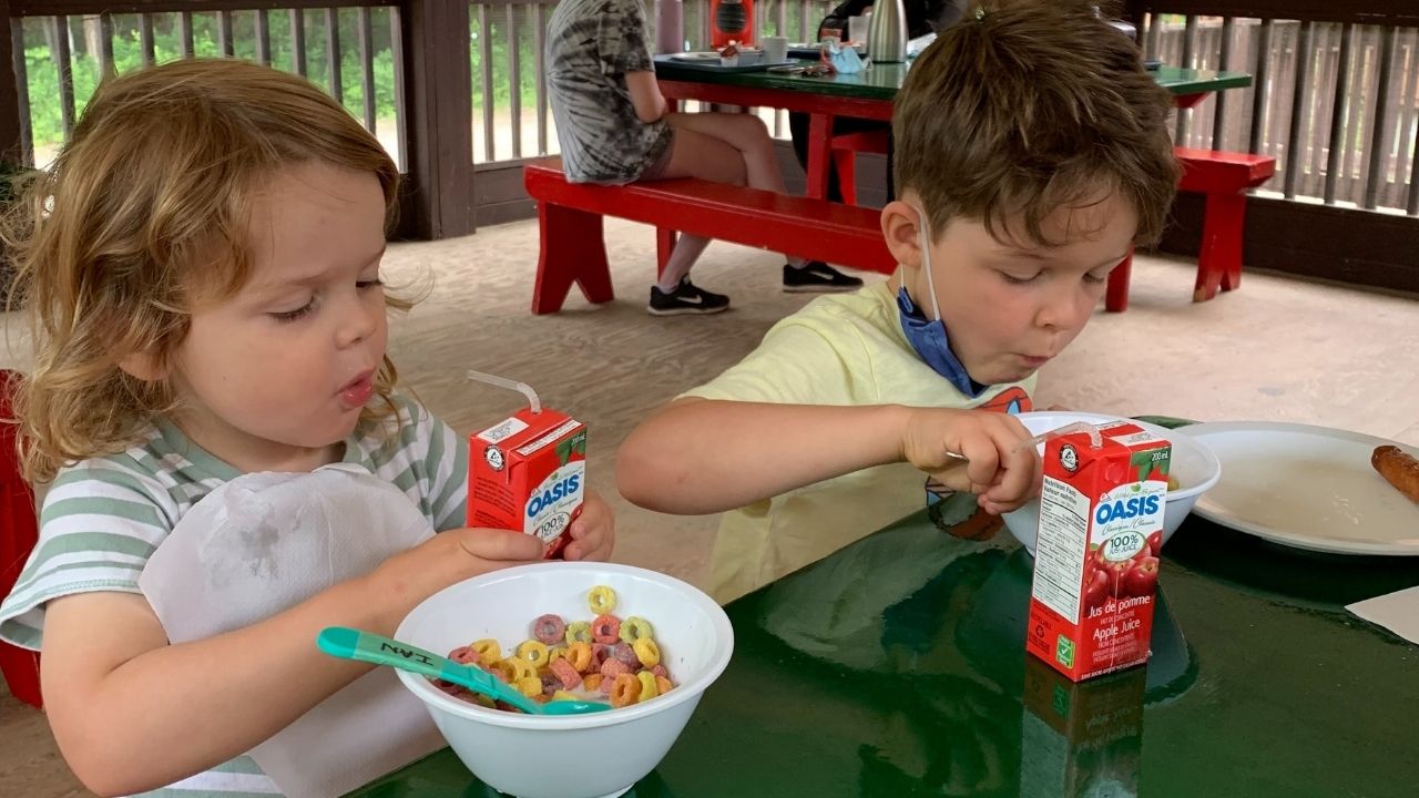 two little boys eating fruit loops and apple juice